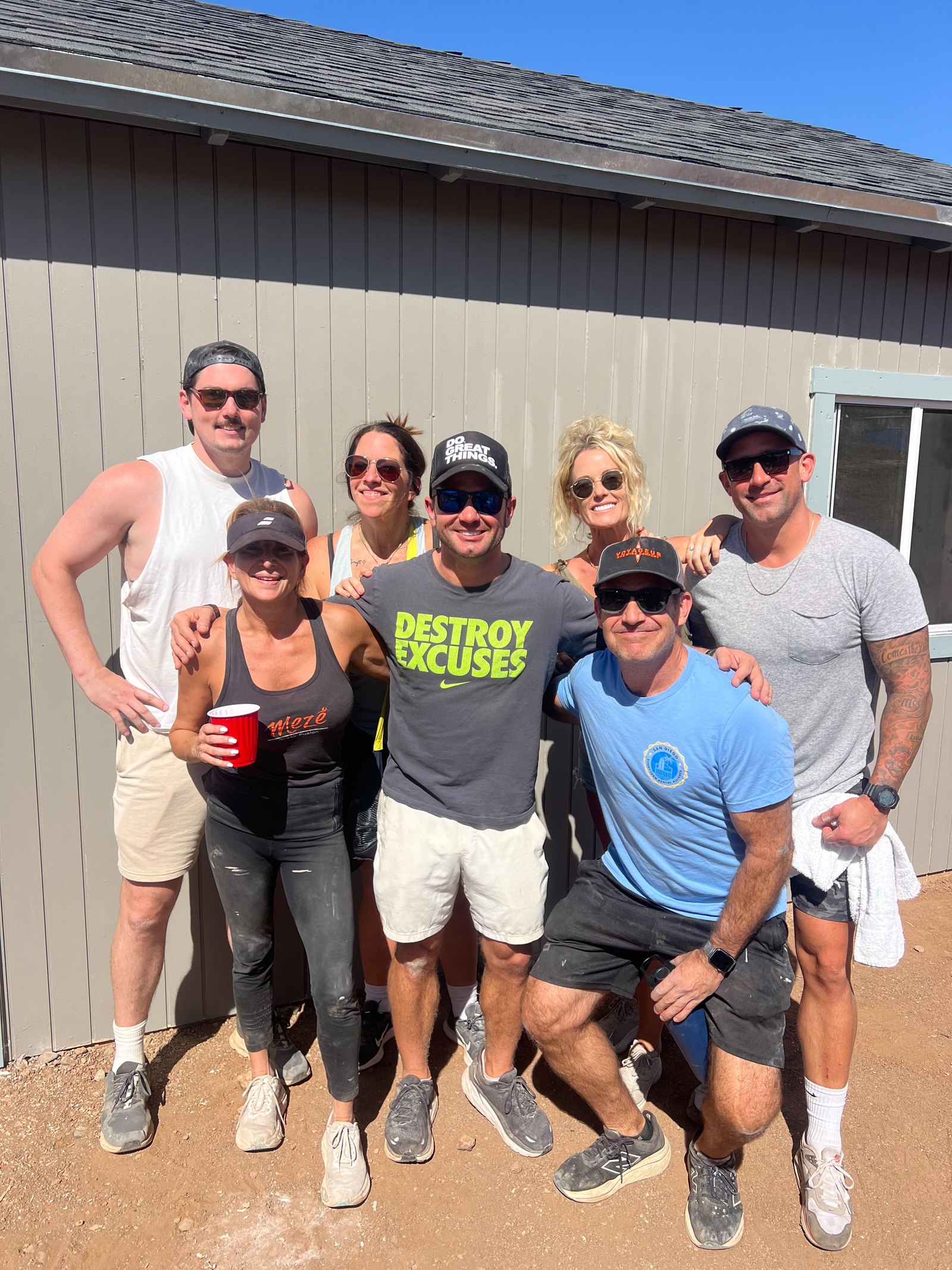 Adult volunteer crew gathers together in front of a finished insulated home